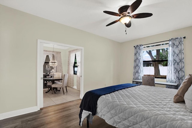 679 Challice Dr, Spring Hill, FL 34609 - bedroom with baseboards, wood finished floors, a chandelier, and ceiling fan