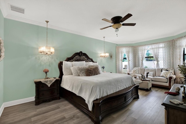 679 Challice Dr, Spring Hill, FL 34609 - bedroom with a chandelier, wood finished floors, crown molding, and baseboards