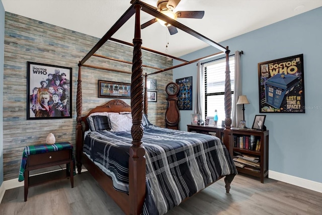 679 Challice Dr, Spring Hill, FL 34609 - bedroom with wood walls, baseboards, wood finished floors, an accent wall, and a ceiling fan
