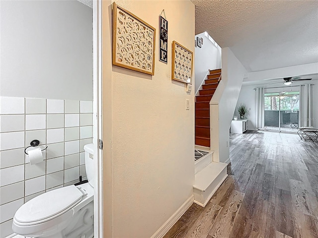 147 114th Ave NE Unit 147, Saint Petersburg, FL 33716 - corridor featuring tile walls, a textured ceiling, wood finished floors, and stairway