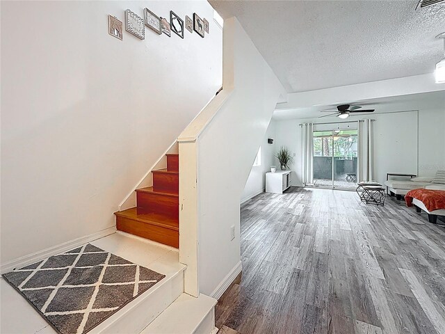 147 114th Ave NE Unit 147, Saint Petersburg, FL 33716 - stairs featuring a textured ceiling, wood finished floors, ceiling fan, and baseboards