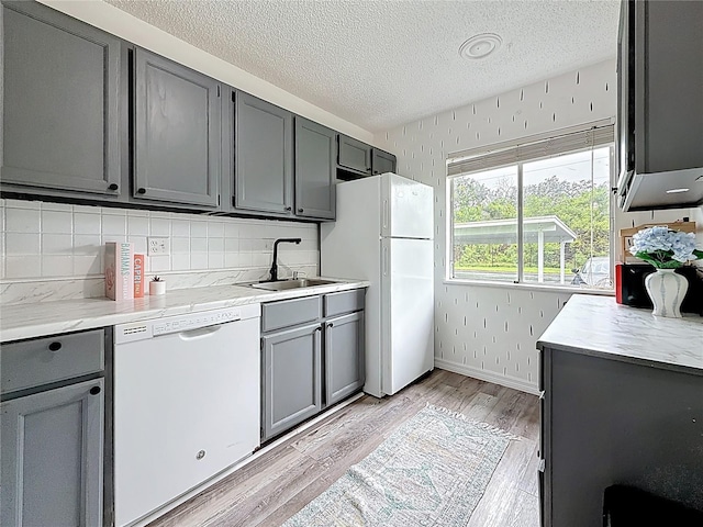 147 114th Ave NE Unit 147, Saint Petersburg, FL 33716 - kitchen featuring white appliances, gray cabinetry, a sink, a textured ceiling, and light wood finished floors