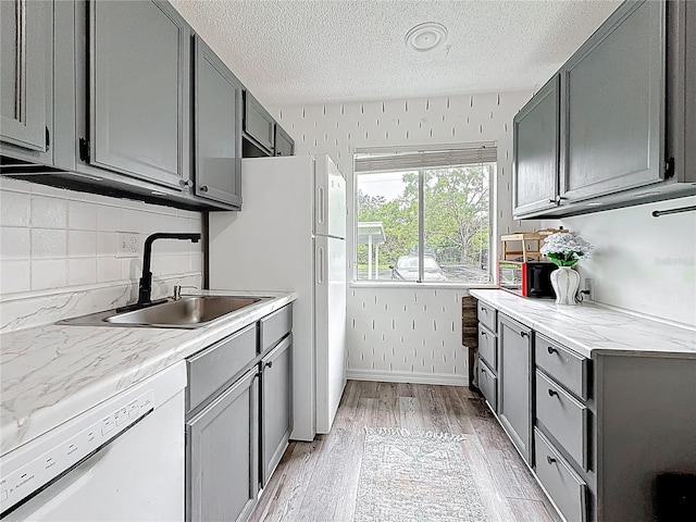 147 114th Ave NE Unit 147, Saint Petersburg, FL 33716 - kitchen featuring white appliances, a sink, gray cabinets, light wood-type flooring, and a textured ceiling