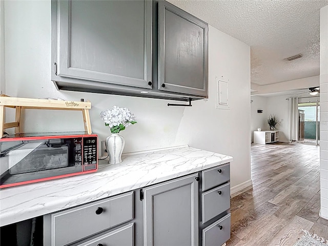 147 114th Ave NE Unit 147, Saint Petersburg, FL 33716 - bar with a textured ceiling, light wood-style flooring, ceiling fan, and baseboards