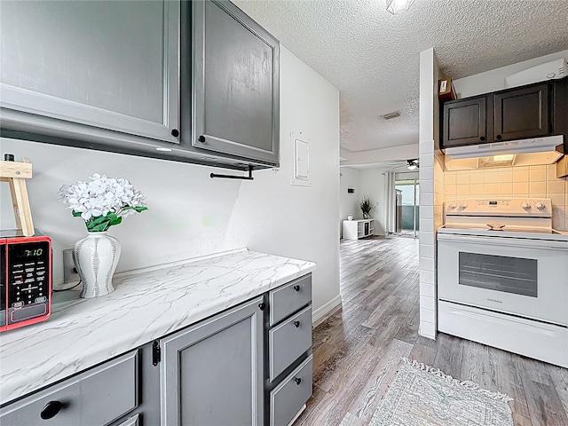 147 114th Ave NE Unit 147, Saint Petersburg, FL 33716 - kitchen with electric range, under cabinet range hood, a ceiling fan, wood finished floors, and gray cabinetry