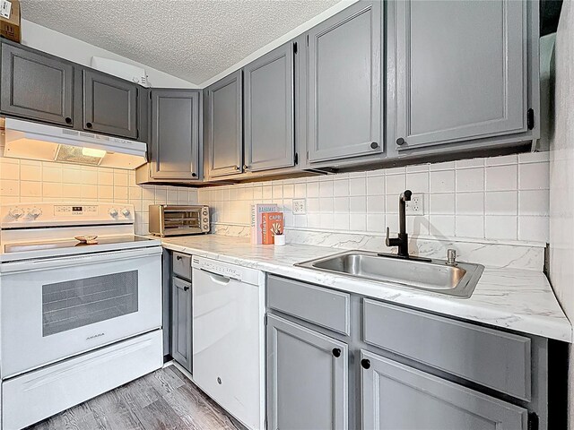 147 114th Ave NE Unit 147, Saint Petersburg, FL 33716 - kitchen featuring white appliances, under cabinet range hood, gray cabinetry, a sink, and a textured ceiling