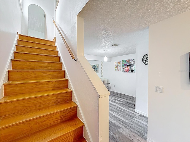 147 114th Ave NE Unit 147, Saint Petersburg, FL 33716 - stairs featuring a textured ceiling, wood finished floors, and baseboards
