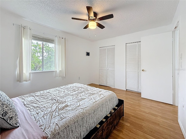 147 114th Ave NE Unit 147, Saint Petersburg, FL 33716 - bedroom featuring two closets, wood finished floors, a textured ceiling, and a ceiling fan