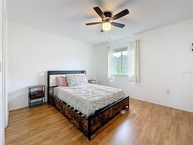147 114th Ave NE Unit 147, Saint Petersburg, FL 33716 - bedroom featuring light wood-style floors, a textured ceiling, a ceiling fan, and baseboards