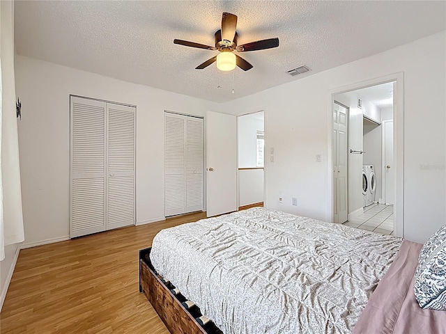 147 114th Ave NE Unit 147, Saint Petersburg, FL 33716 - bedroom featuring independent washer and dryer, two closets, light wood-type flooring, a textured ceiling, and a ceiling fan