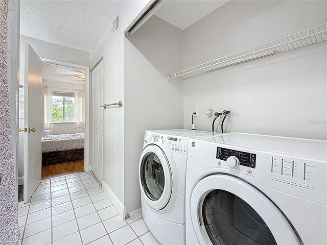 147 114th Ave NE Unit 147, Saint Petersburg, FL 33716 - washroom featuring light tile patterned floors, washer and clothes dryer, a textured ceiling, and baseboards