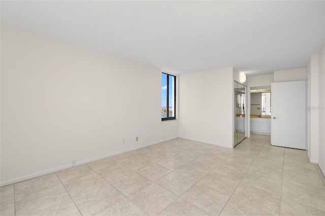 9425 Blind Pass Rd Unit 1008, St Pete Beach, FL 33706 - empty room with baseboards and light tile patterned floors