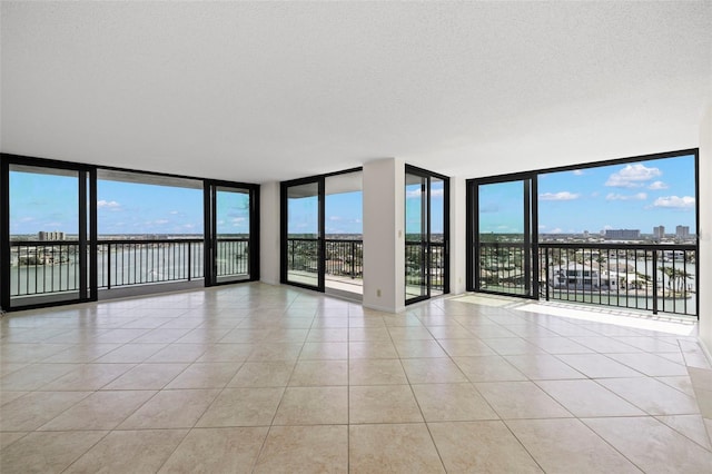 9425 Blind Pass Rd Unit 1008, St Pete Beach, FL 33706 - empty room featuring light tile patterned floors and floor to ceiling windows