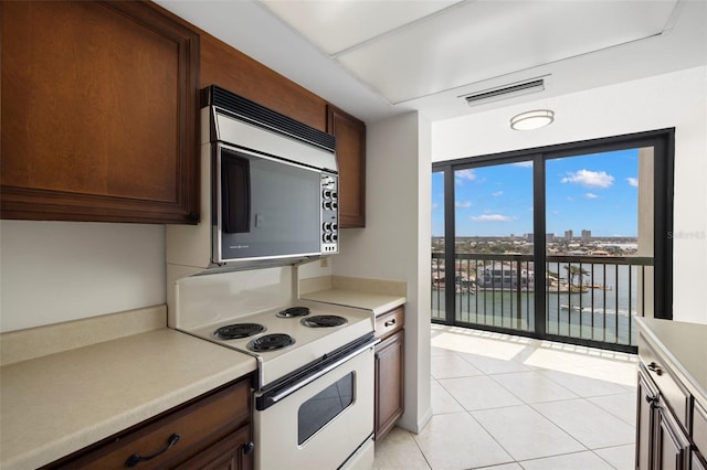 9425 Blind Pass Rd Unit 1008, St Pete Beach, FL 33706 - kitchen featuring electric stove, stainless steel microwave, light tile patterned flooring, and light countertops