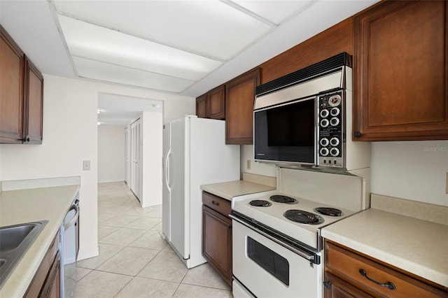 9425 Blind Pass Rd Unit 1008, St Pete Beach, FL 33706 - kitchen with appliances with stainless steel finishes, light tile patterned flooring, light countertops, and a sink
