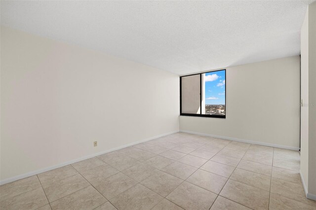 9425 Blind Pass Rd Unit 1008, St Pete Beach, FL 33706 - unfurnished room featuring tile patterned floors, a textured ceiling, and baseboards