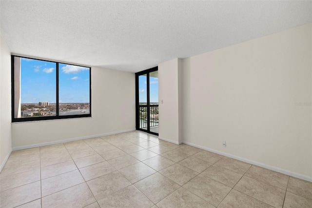 9425 Blind Pass Rd Unit 1008, St Pete Beach, FL 33706 - tiled empty room featuring a textured ceiling and baseboards