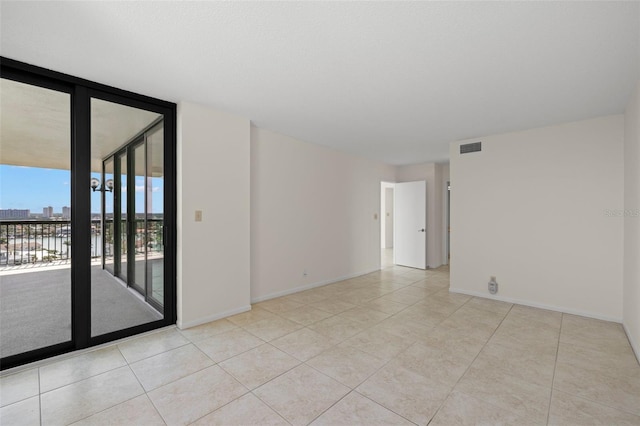 9425 Blind Pass Rd Unit 1008, St Pete Beach, FL 33706 - tiled empty room featuring baseboards and a wall of windows