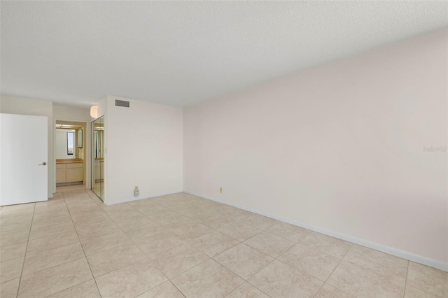 9425 Blind Pass Rd Unit 1008, St Pete Beach, FL 33706 - spare room with light tile patterned flooring and baseboards