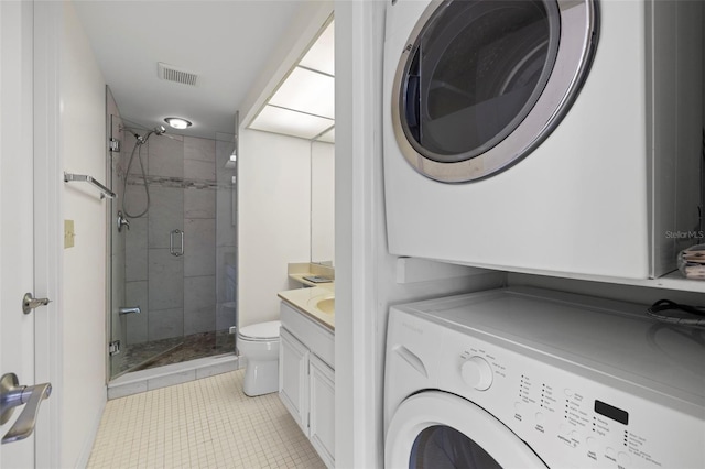 9425 Blind Pass Rd Unit 1008, St Pete Beach, FL 33706 - laundry room featuring stacked washer and clothes dryer and light tile patterned flooring