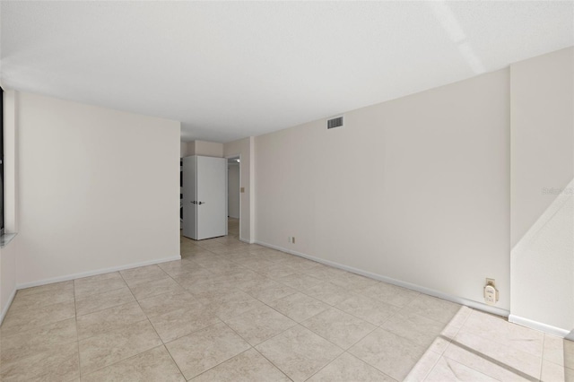 9425 Blind Pass Rd Unit 1008, St Pete Beach, FL 33706 - spare room featuring light tile patterned floors and baseboards