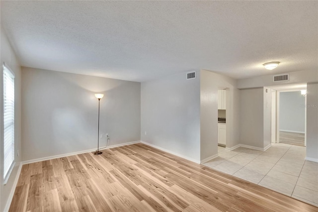125 Picardy Villa Cir Unit 100, Brandon, FL 33510 - empty room with a textured ceiling, light wood-type flooring, and baseboards