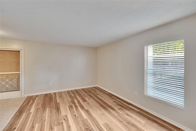 125 Picardy Villa Cir Unit 100, Brandon, FL 33510 - empty room featuring light wood-style floors, a textured ceiling, and baseboards