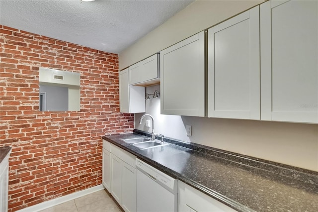 125 Picardy Villa Cir Unit 100, Brandon, FL 33510 - kitchen featuring dishwasher, a sink, a textured ceiling, dark countertops, and light tile patterned floors