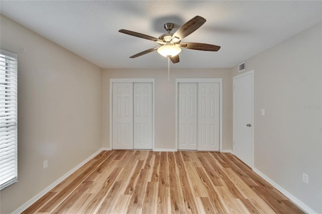 125 Picardy Villa Cir Unit 100, Brandon, FL 33510 - unfurnished bedroom with two closets, light wood-type flooring, multiple windows, and baseboards