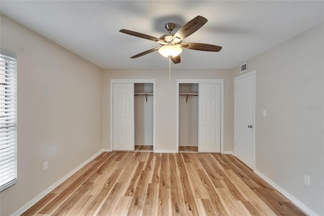 125 Picardy Villa Cir Unit 100, Brandon, FL 33510 - unfurnished bedroom with two closets, light wood-style flooring, baseboards, and ceiling fan