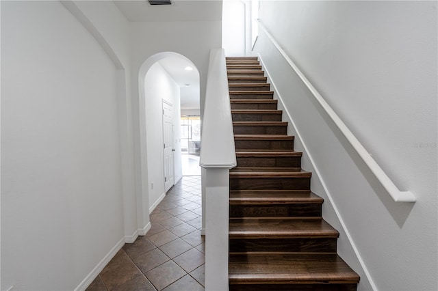 6940 47th Way N, Pinellas Park, FL 33781 - staircase with tile patterned flooring, arched walkways, and baseboards