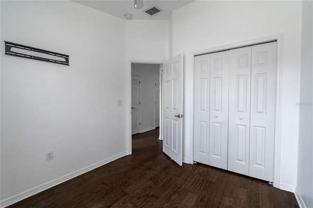 6940 47th Way N, Pinellas Park, FL 33781 - unfurnished bedroom with dark wood-style flooring, baseboards, and a closet