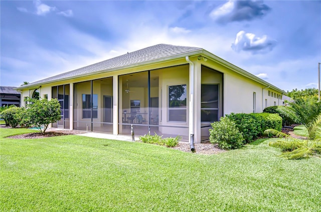 4304 Place Le Manes, Lutz, FL 33558 - rear view of house featuring a sunroom, a yard, stucco siding, and a shingled roof