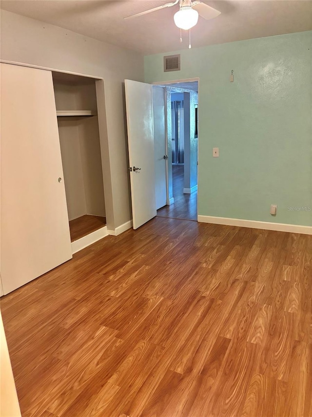 4020 55th St N Unit 1106, Kenneth City, FL 33709 - unfurnished bedroom with wood finished floors, a ceiling fan, baseboards, and a closet