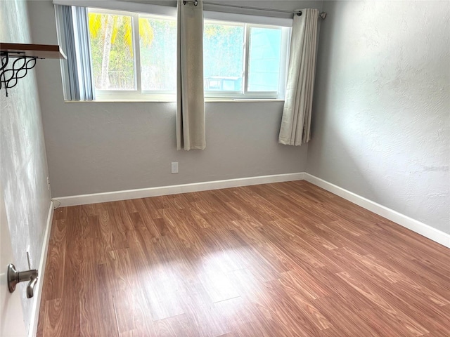 4020 55th St N Unit 1106, Kenneth City, FL 33709 - empty room featuring healthy amount of natural light, wood finished floors, and baseboards