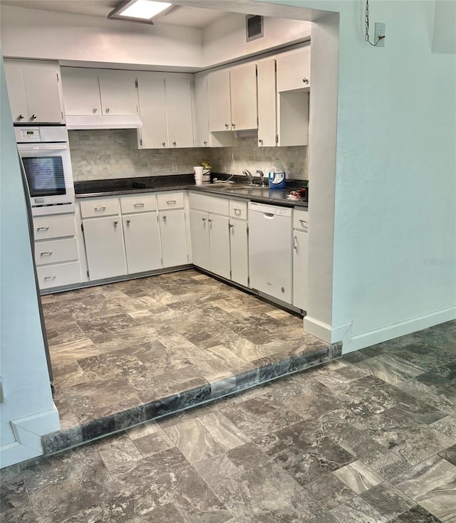 4020 55th St N Unit 1106, Kenneth City, FL 33709 - kitchen with white appliances, dark countertops, tasteful backsplash, a sink, and baseboards