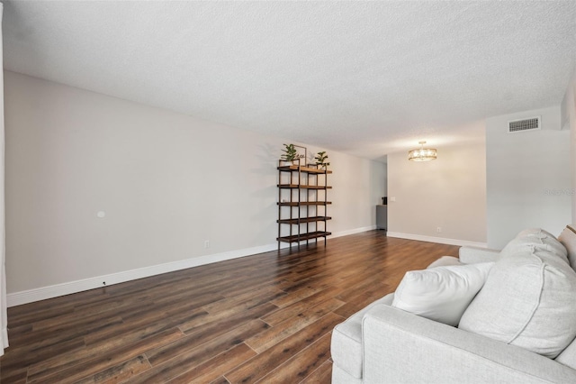 2461 Rhodesian Dr Unit 47, Clearwater, FL 33763 - living area with a chandelier, dark wood-style flooring, a textured ceiling, and baseboards