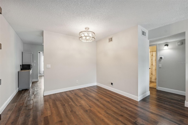 2461 Rhodesian Dr Unit 47, Clearwater, FL 33763 - empty room with a textured ceiling, dark wood-style floors, a chandelier, and baseboards