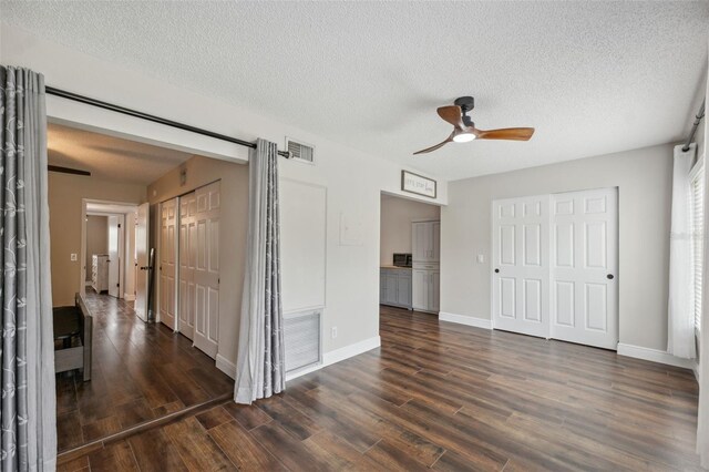 2461 Rhodesian Dr Unit 47, Clearwater, FL 33763 - unfurnished bedroom with dark wood-style floors, a textured ceiling, baseboards, and ceiling fan