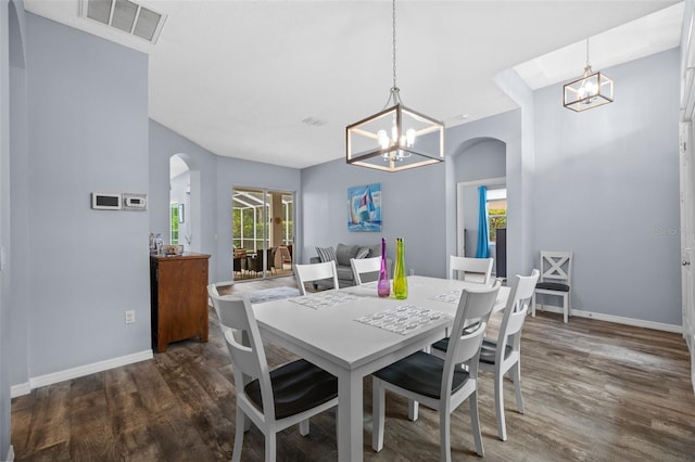 4505 Anaconda Dr, New Port Richey, FL 34655 - dining space featuring a chandelier, arched walkways, healthy amount of natural light, and wood finished floors