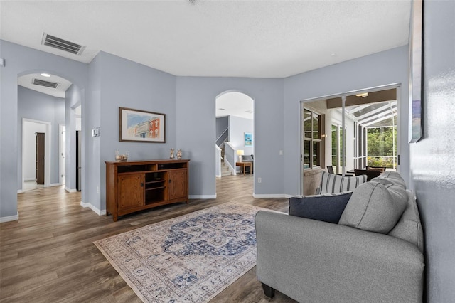 4505 Anaconda Dr, New Port Richey, FL 34655 - living room with arched walkways, stairway, wood finished floors, and baseboards
