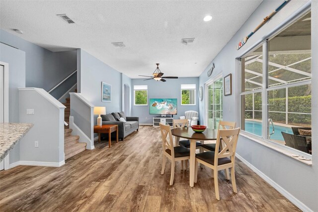 4505 Anaconda Dr, New Port Richey, FL 34655 - dining space featuring wood finished floors, a textured ceiling, ceiling fan, stairway, and baseboards