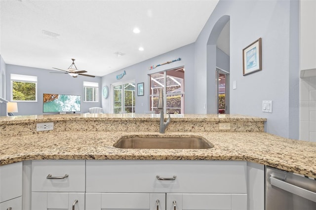 4505 Anaconda Dr, New Port Richey, FL 34655 - kitchen featuring a sink, dishwasher, a ceiling fan, white cabinets, and light stone countertops