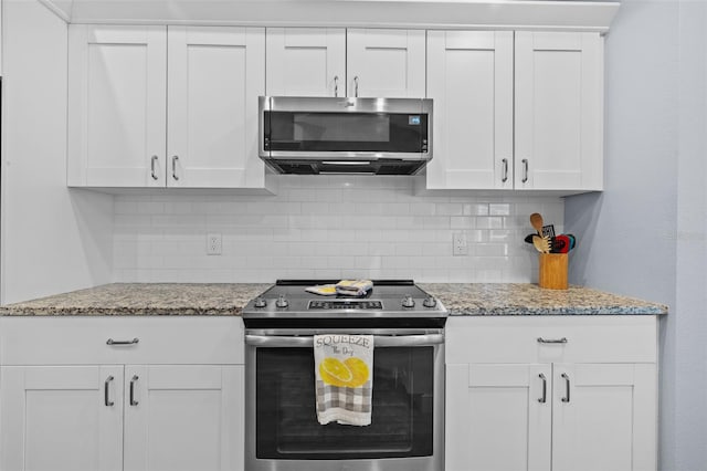 4505 Anaconda Dr, New Port Richey, FL 34655 - kitchen featuring stainless steel appliances, backsplash, white cabinetry, and light stone countertops