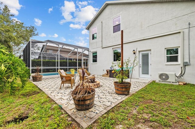 4505 Anaconda Dr, New Port Richey, FL 34655 - rear view of house featuring an outdoor fire pit, ac unit, a patio area, a lanai, and stucco siding