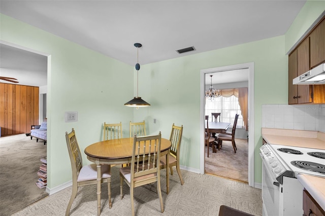 321 Belle View Ave, Temple Terrace, FL 33617 - dining area with light colored carpet, a chandelier, and baseboards