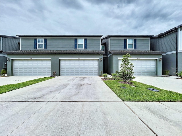 32451 Limitless Pl, Wesley Chapel, FL 33545 - townhome / multi-family property featuring an attached garage, stucco siding, and concrete driveway