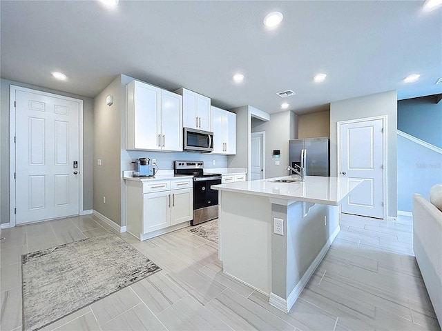 32451 Limitless Pl, Wesley Chapel, FL 33545 - kitchen with appliances with stainless steel finishes, a sink, baseboards, white cabinets, and light countertops