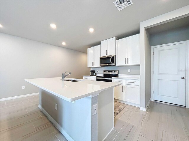 32451 Limitless Pl, Wesley Chapel, FL 33545 - kitchen with stainless steel appliances, a sink, a kitchen island with sink, recessed lighting, and baseboards