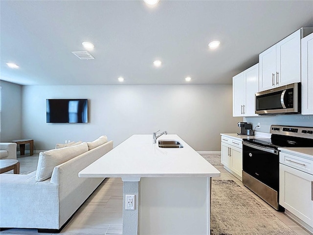32451 Limitless Pl, Wesley Chapel, FL 33545 - kitchen with stainless steel appliances, a sink, recessed lighting, open floor plan, and light countertops